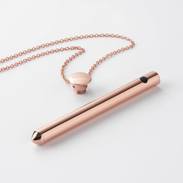 rose gold cylinder necklace and chain on black background